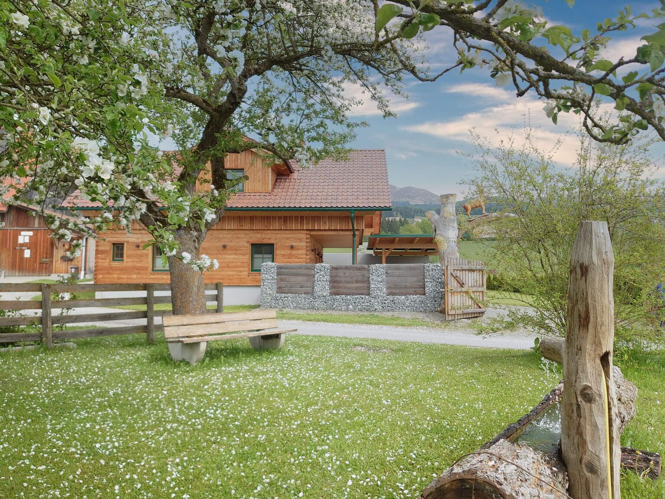 Die Alpensteinbock-Hütte am Greim mit Brunnen vor der Hütte.