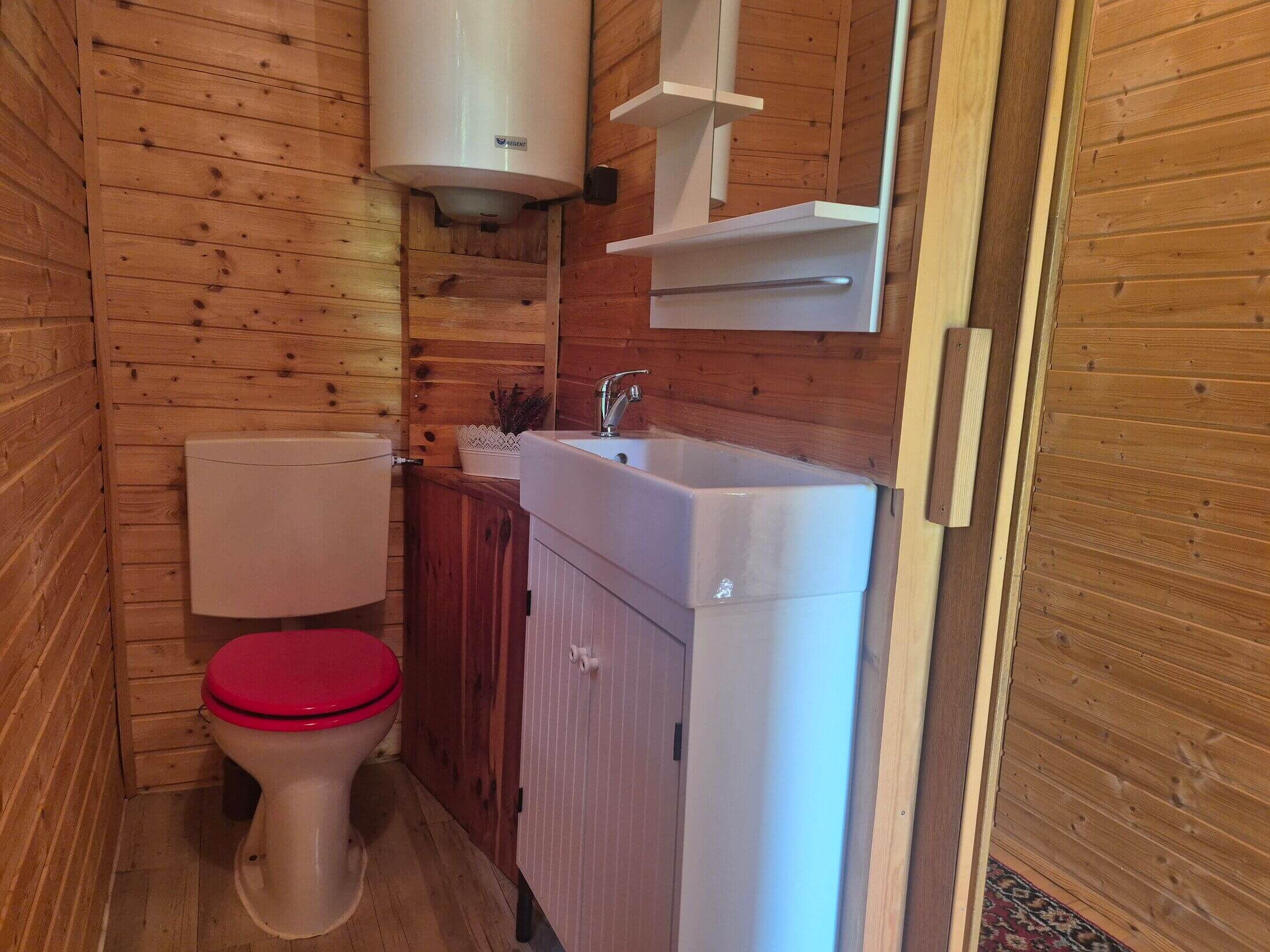 Das Badezimmer im Kochhäusl mit Toilette, Waschtisch und Fenster mit Blick ins Freie.