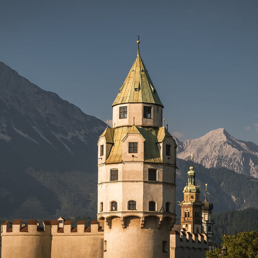 Münzturm in Hall in Tirol mit Bergkette zurück.