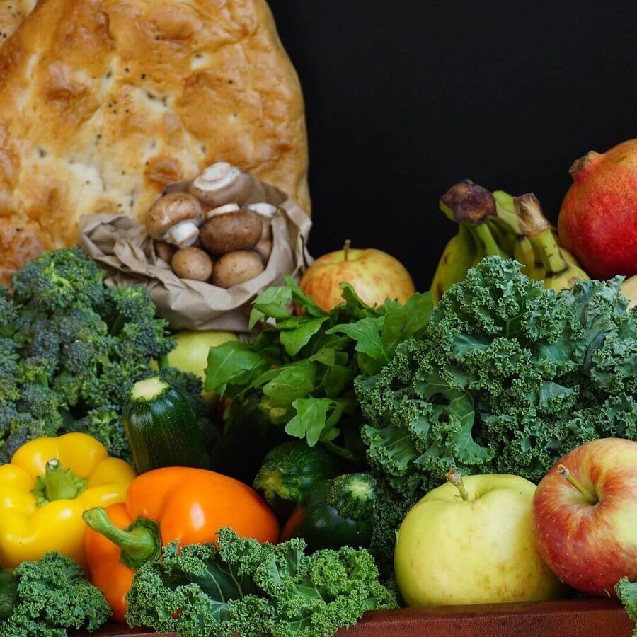 Vorbereitung für den Bergurlaub: Eine sorgfältig zusammengestellte Einkaufsliste mit Lebensmitteln wie Obst, Gemüse, Brot und Konserven, um in der Hütte oder Ferienwohnung selbst zu kochen und die Freiheit des Urlaubs zu genießen.