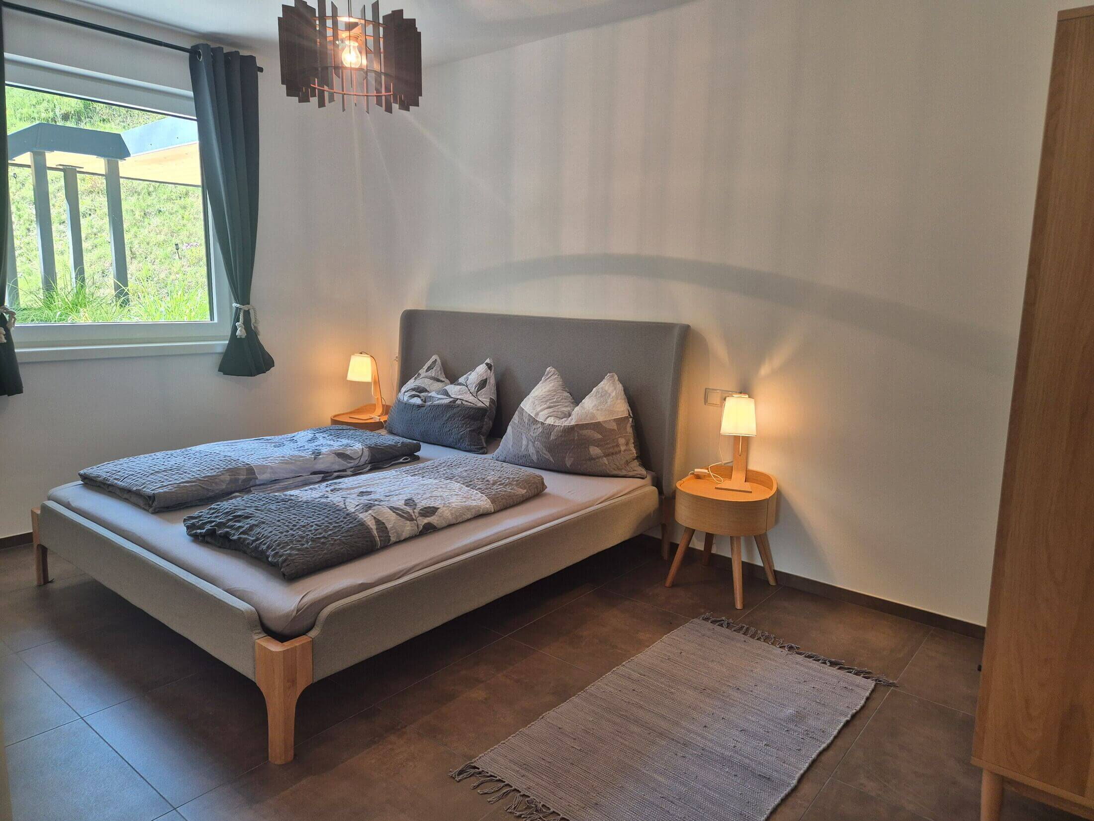 Die Ferienwohnung Waldsicht bietet ein gemütliches Schlafzimmer mit Blick in die Natur.