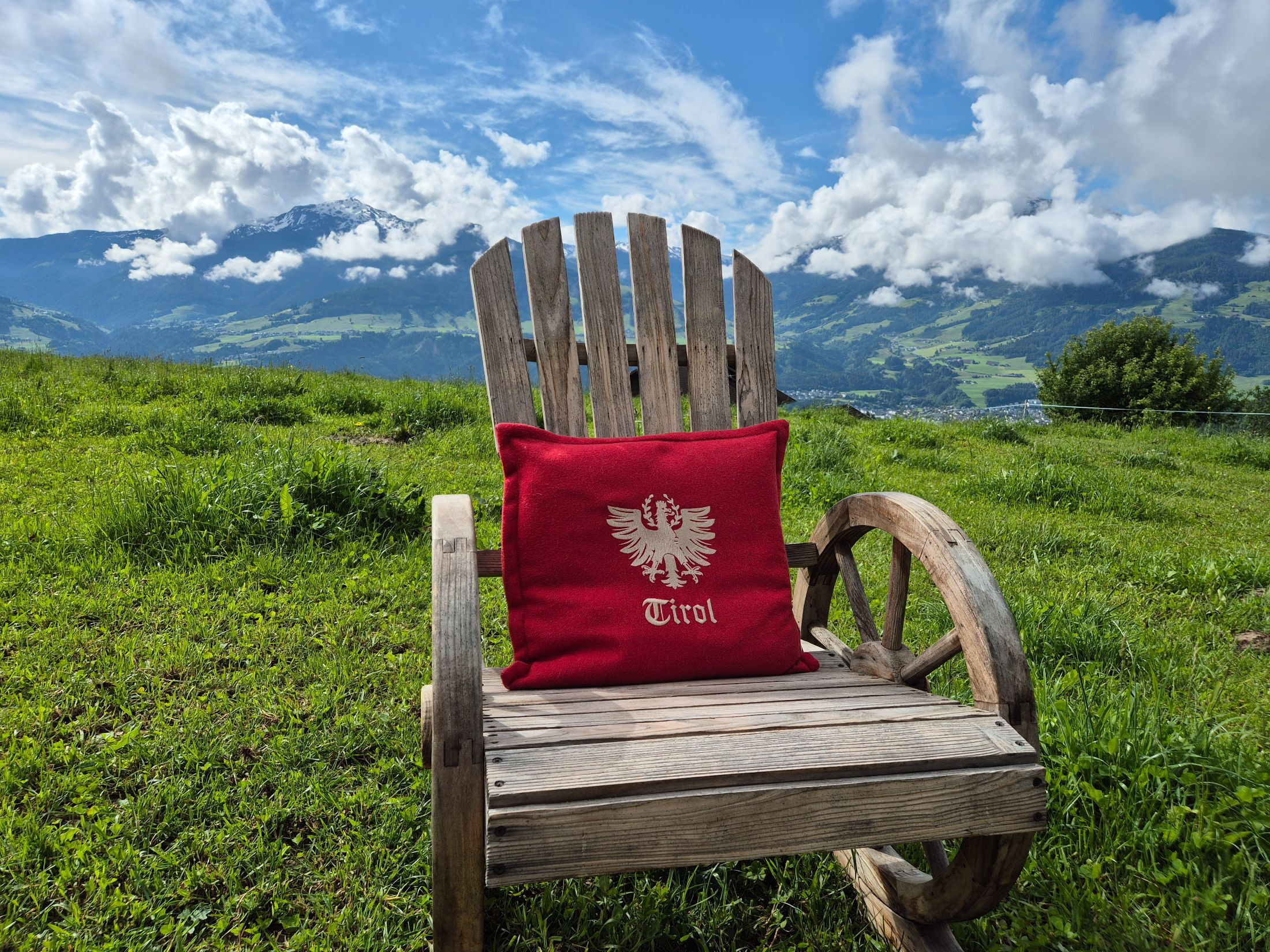 Schaukelstuhl aus Holz und im Hintergrund die Bergkulisse.