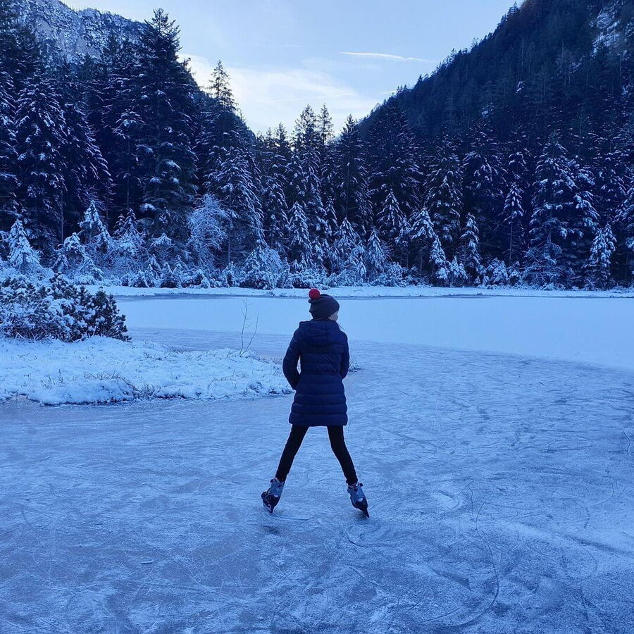 Über den zu gefrorenen Bergsee mit den Schlittschuhen gleiten.