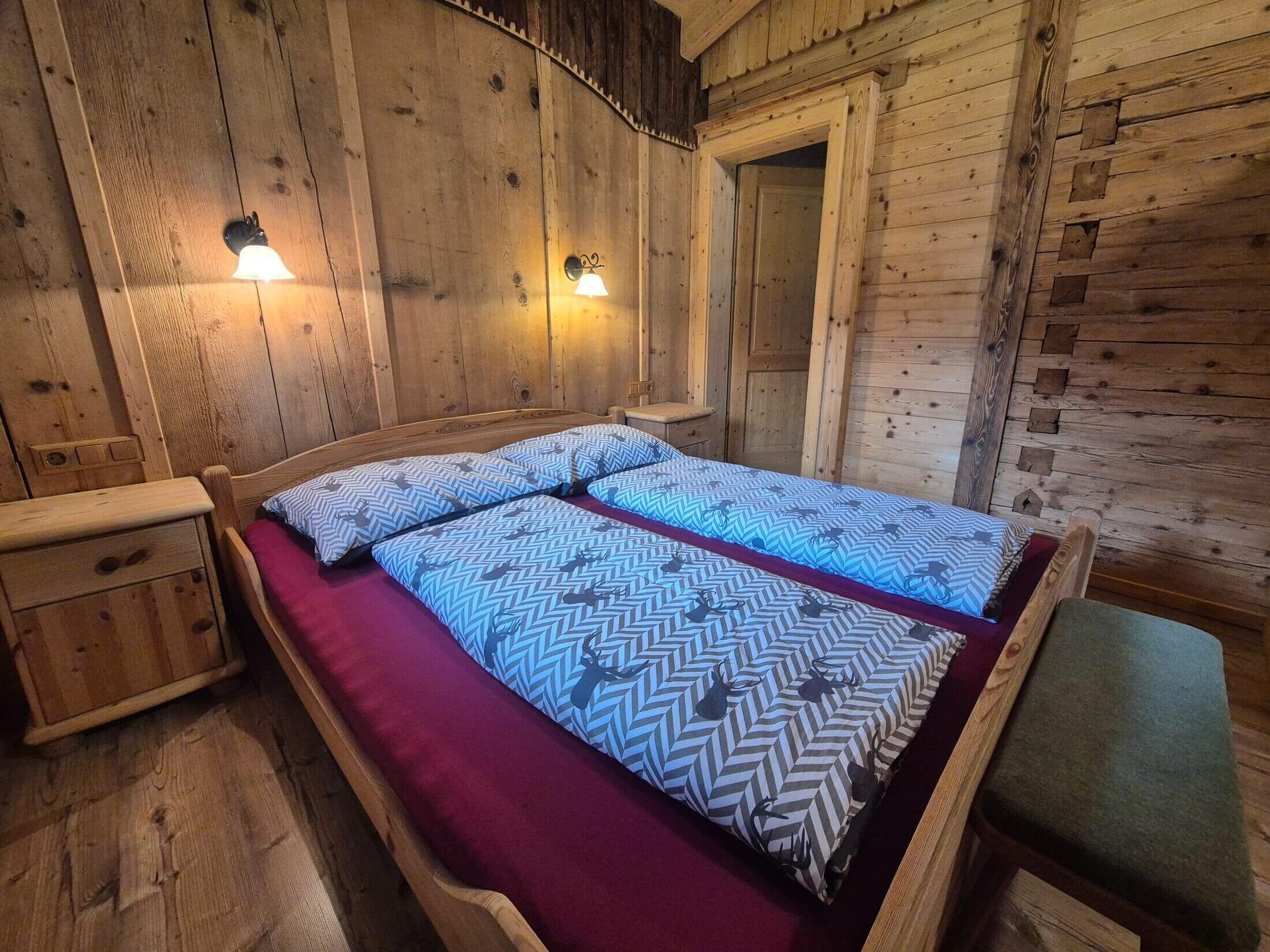 Das Schlafzimer mit Doppelbett in der alten Brennhütte im Zillertal.