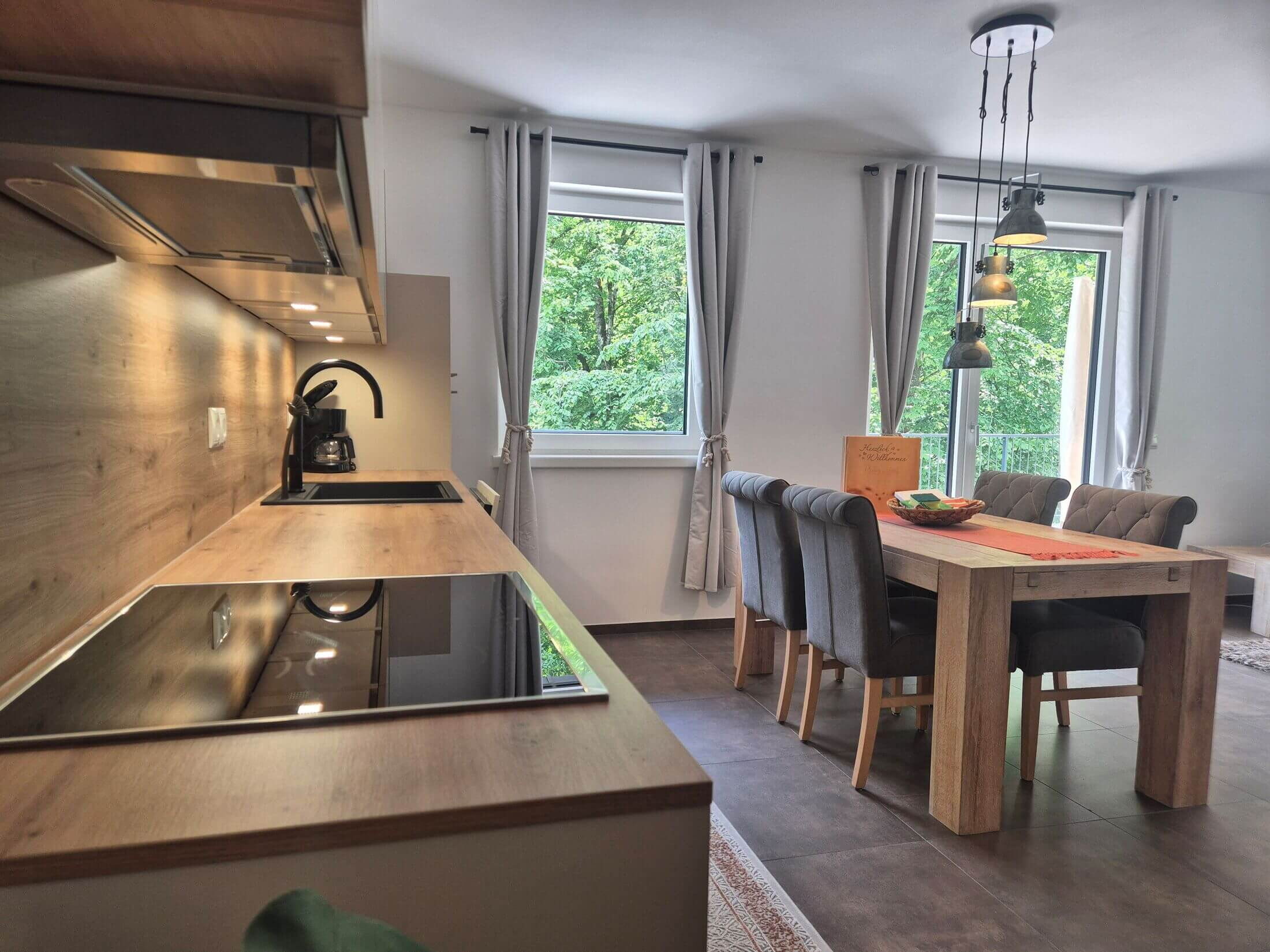 Die Ferienwohnung Waldsicht mit Küchenzeile und Esstisch.