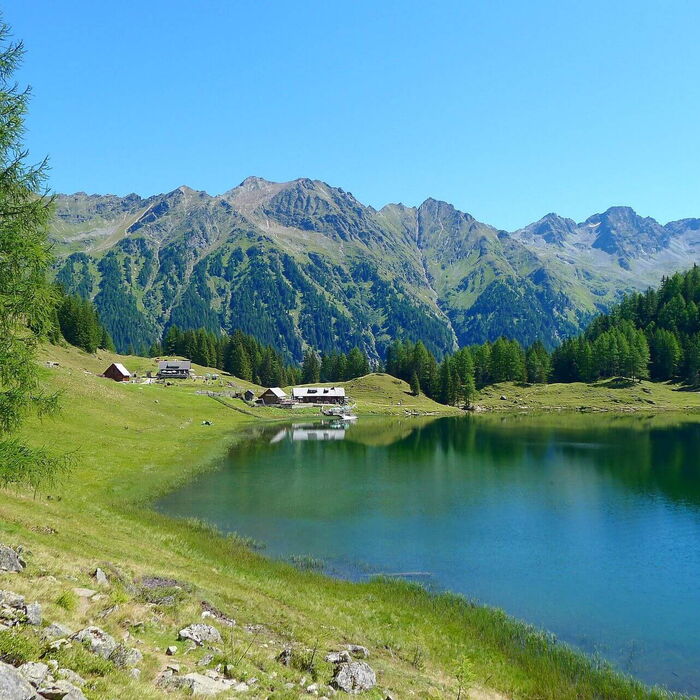 Die Steiermark mit einem Bergsee und im Hintergrund die Alpen.